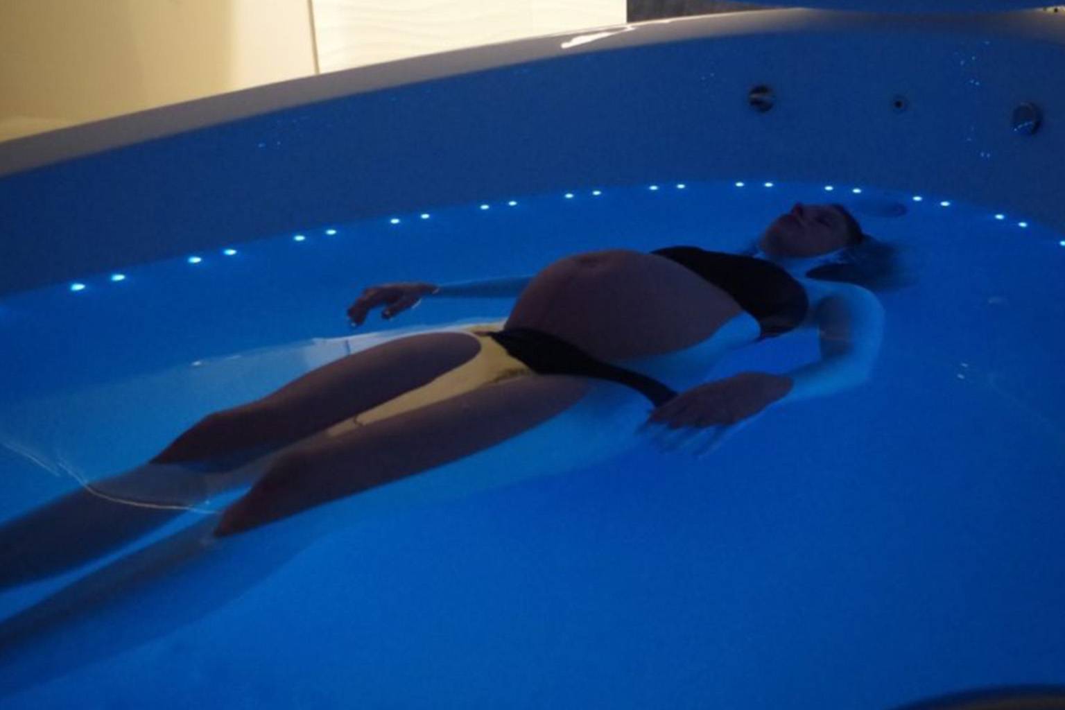 pregnant woman floating in a sensory depravation tank